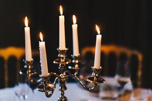 Burning candles on bronze candlestick against dark background at home. Vintage style. Calm romantic atmosphere. Horizontal image for design. photo