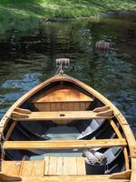 un bote de remos de madera visto desde arriba mientras se mece en el agua. foto