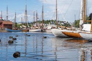 veleros de madera reflejados en el agua en fredrikstad, noruega. foto