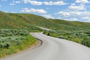 A winding road ascending the hill side toward a blue sky. photo