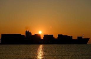 A ship leaving port at sunrise photo