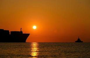 un barco que sale del puerto al amanecer foto