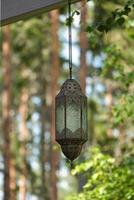 Hanging lamp on a track in front of a forest of metal and glass. Oriental processing photo