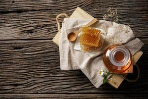 abeja de miel en tarro y panal con cucharón de miel y flor en mesa de madera, productos de abeja por concepto de ingredientes naturales orgánicos, espacio de copia para su texto