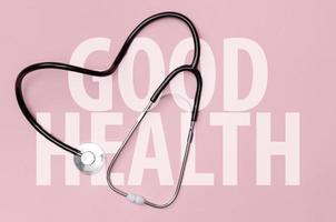 Stethoscope in shape of heart on pink table background, Good health from Doctor concept, Top view with copy space, Isolated on pink photo