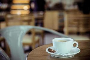 Cup of coffee on table in cafe - vintage style effect picture photo
