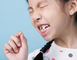 Asian child's hand shows the fallen out small white milk teeth close-up, Dentistry and Health care concept photo