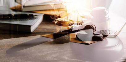 Justice and law concept.Male judge in a courtroom with the gavel, working with, computer and docking keyboard, eyeglasses, on table in morning light photo