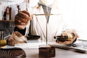 Business and lawyers discussing contract papers with brass scale on desk in office. Law, legal services, advice, justice and law concept picture with film grain effect photo