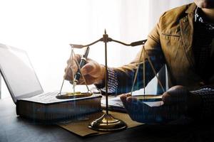 Justice and law concept.Male judge in a courtroom with the gavel, working with, computer and docking keyboard, eyeglasses, on table in morning light photo