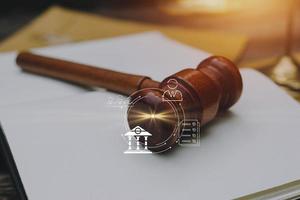 Justice and law concept.Male judge in a courtroom with the gavel, working with, computer and docking keyboard, eyeglasses, on table in morning light photo