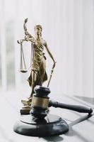 Justice and law concept. Gavel on sounding block in hand's Male judge at a courtroom, working with document law books, report the case on table in modern office. photo