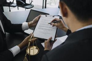 concepto de justicia y derecho. mazo en el bloque de sonido en la mano del juez masculino en una sala del tribunal, trabajando con libros de derecho de documentos, informe el caso sobre la mesa en la oficina moderna. foto