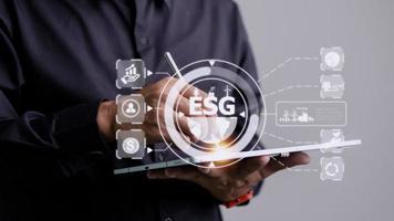 explorer at ipad communication tool ready to study Renewable resources to reduce pollution In concept ESG icons in hand for environmental, social and sustainable business governance. photo