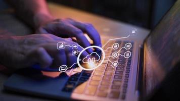 man use Laptop with cloud computing diagram show on hand. Cloud technology. Data storage. Networking and internet service concept. photo