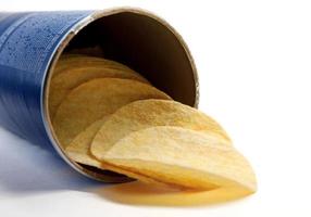 Potato chips are poured out of a can of chips. photo