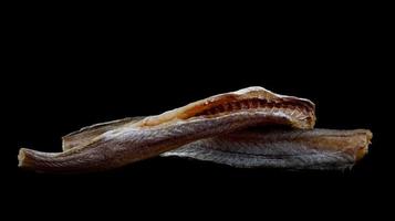 dried blue whiting , on a black background photo