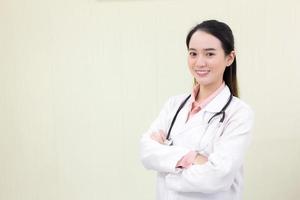 Asian female doctor stands and cross arms in office at hospital. photo