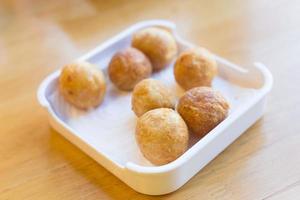 Fried premium shrimp ball made from fresh shrimp suitable to be served with noodles on a white plate. Selective focus with shallow depth of field on the top view. Delicious crispy shrimp balls. photo