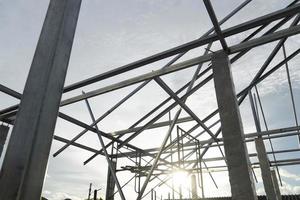 estructura de techo de acero conectada a columnas de cemento bajo el cielo. con la luz del sol en la noche. foto