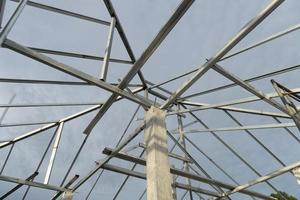 estructura de techo de acero conectada a columnas de cemento bajo el cielo. foto