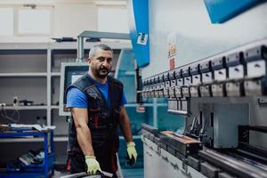 un trabajador o ingeniero de fábrica inteligente fabrica máquinas en un taller de producción. el concepto de industria e ingeniería. enfoque selectivo foto