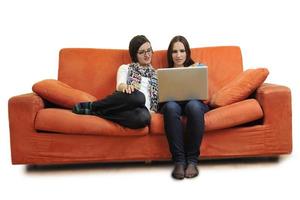 female friends working on laptop computer at home photo