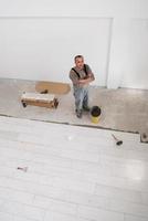 worker installing the ceramic wood effect tiles on the floor photo