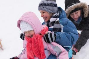 group of kids having fun and play together in fresh snow photo