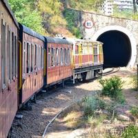 Toy Train moving on mountain slopes, beautiful view, one side mountain, one side valley moving on railway to the hill, among green natural forest. Toy train from Kalka to Shimla in India, Indian Train photo