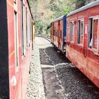 tren de juguete moviéndose en las laderas de las montañas, hermosa vista, una montaña lateral, un valle lateral moviéndose en ferrocarril hacia la colina, entre bosques naturales verdes. tren de juguete de kalka a shimla en india, tren indio foto