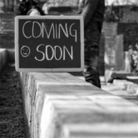 Indian couple posing for maternity baby shoot. The couple is posing in a lawn with green grass and the woman is falunting her baby bump in Lodhi Garden in New Delhi, India - Black and White photo