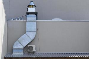 Hood with a pipe behind a restaurant in a shopping center. photo