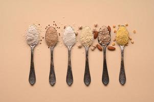 Spoons of various gluten free flour. Flat lay, top. photo