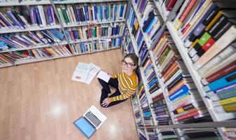 el estudiante usa un cuaderno y una biblioteca escolar foto