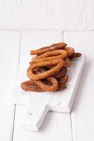 Homemade churros on a white wooden background. photo