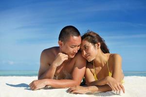 feliz pareja joven disfrutando del verano en la playa foto