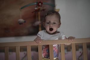 cute  little one year old baby and making first steps in bed photo