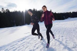 couple jogging outside on snow photo