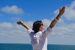 young woman with spreading arms to sky photo