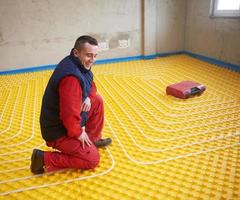 workers installing underfloor heating system photo