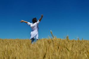 young woman in wheat field at summer photo