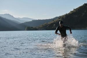 atleta de triatlón comenzando a nadar en el lago foto