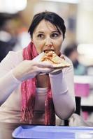 mujer come pizza en el restaurante foto