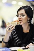 mujer come pizza en el restaurante foto