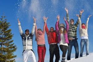 los amigos se divierten en invierno con nieve fresca foto