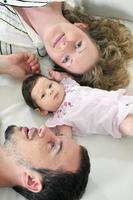 retrato interior con una familia joven feliz y un lindo bebé foto