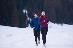 pareja trotando afuera en la nieve foto