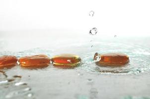 isolated wet zen stones with splashing  water drops photo