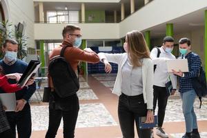estudiantes saludando el nuevo apretón de manos normal de coronavirus y golpes de codo foto